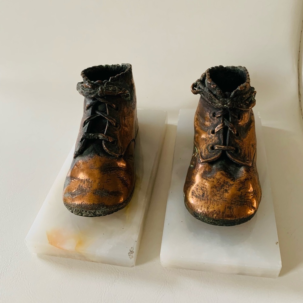 Copper vintage baby shoes figurine decoration on marble base